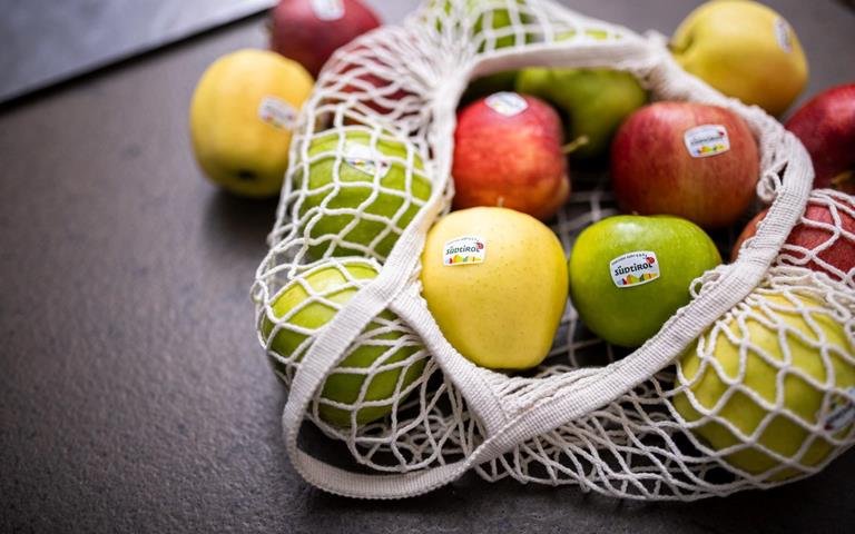 Una borsa di stoffa piena di mele altoatesine di diverse varietà.